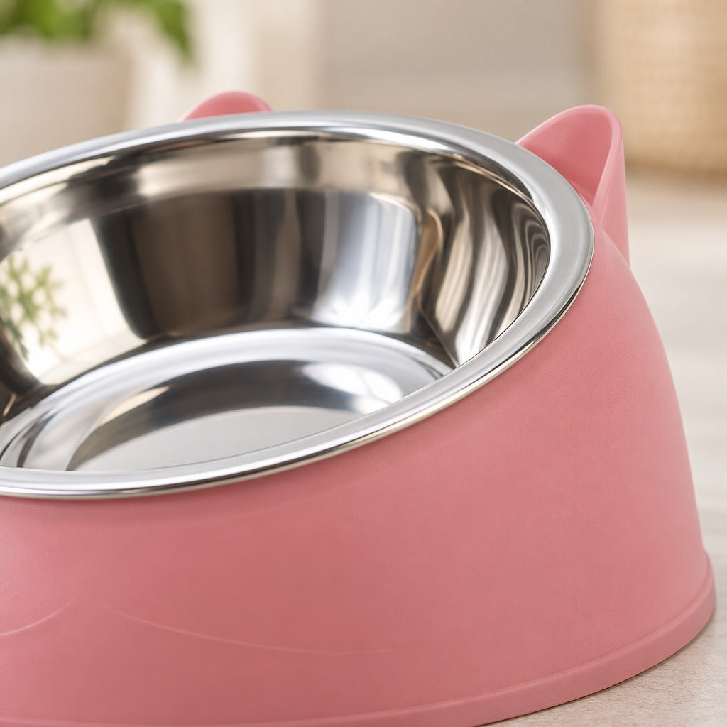 Gros plan sur le bord en acier poli et sur une oreille du bol à oreilles pour chat, coloris rose poudré.