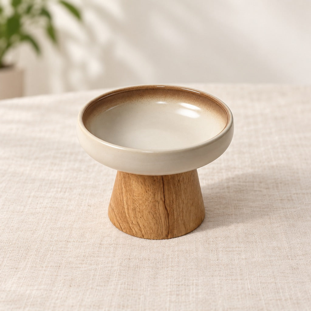 Le bol rétro crème et bois naturel seul sur une toile de lin, vu de trois quarts au dessus de la lèvre, le socle conique entier dans le cadre.