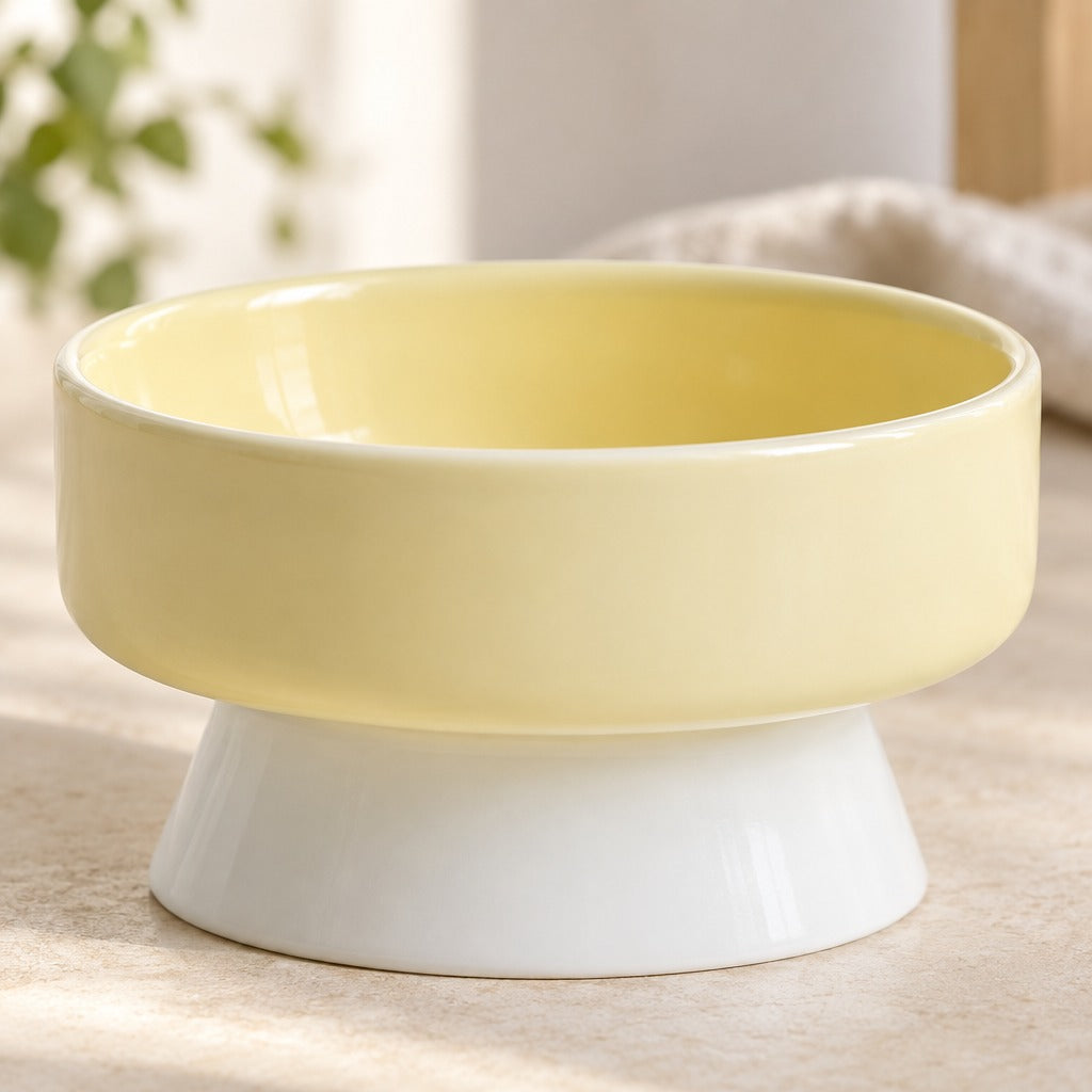 Gros plan sur l'émail brillant du bol surélevé jaune pâle, modèle bol creux, et sur son pied blanc évasé moulé d'une seule pièce.