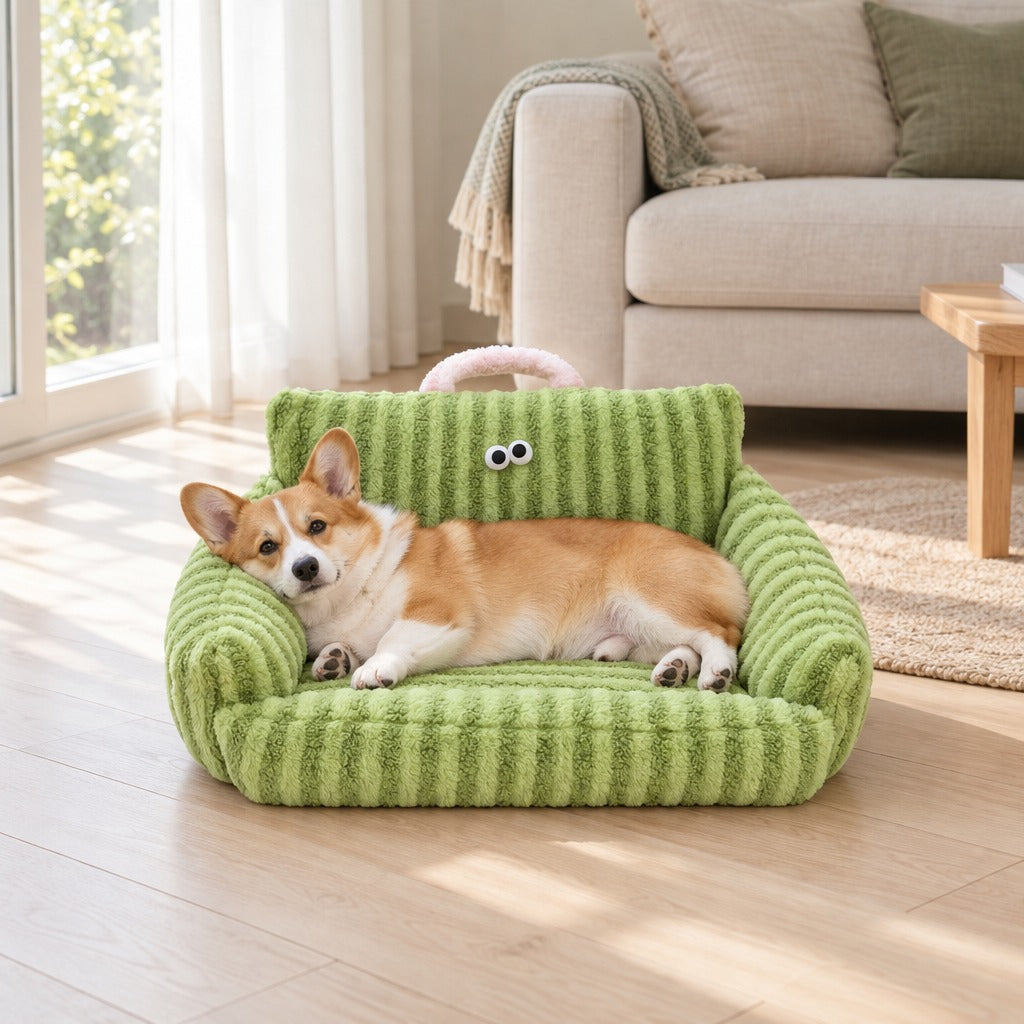 Corgi couche de tout son long dans le couchage canape vert pomme installe au pied d'un canape en lin, vu de loin dans la piece.