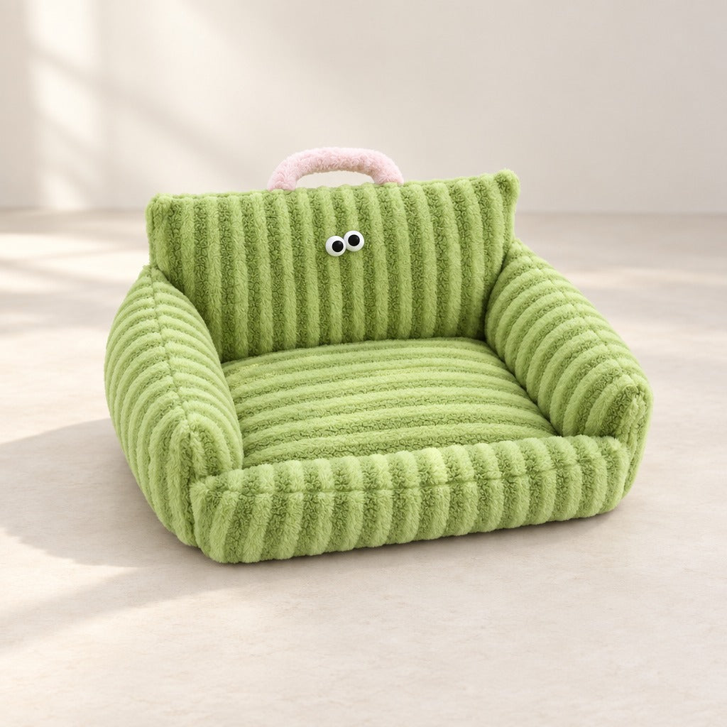 Le couchage canape en peluche rayee vert pomme seul, de trois quarts, avec ses deux yeux et sa poignee rose.