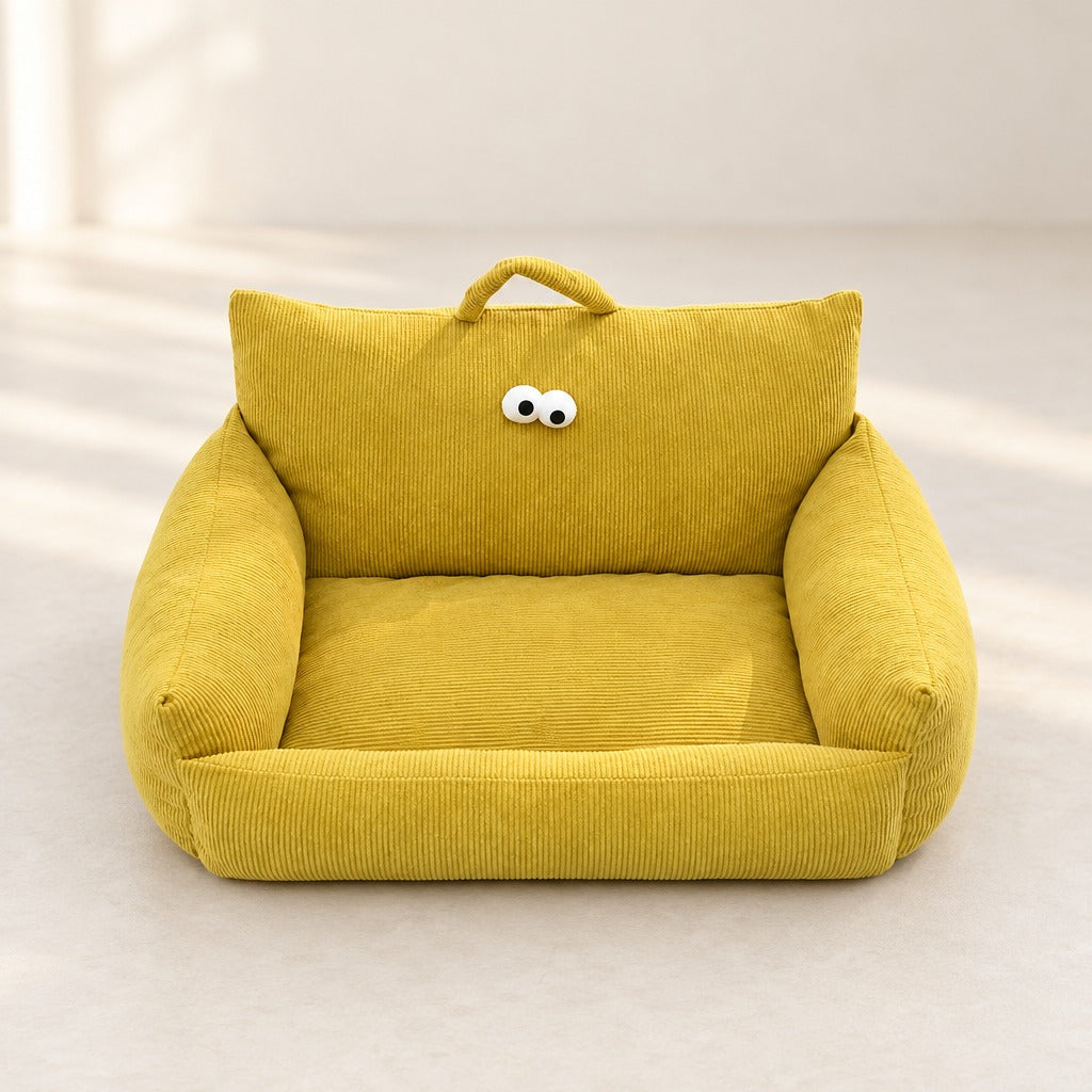 Le couchage canape en velours cotele ocre seul, vu de face, ses deux yeux et sa poignee bien visibles.
