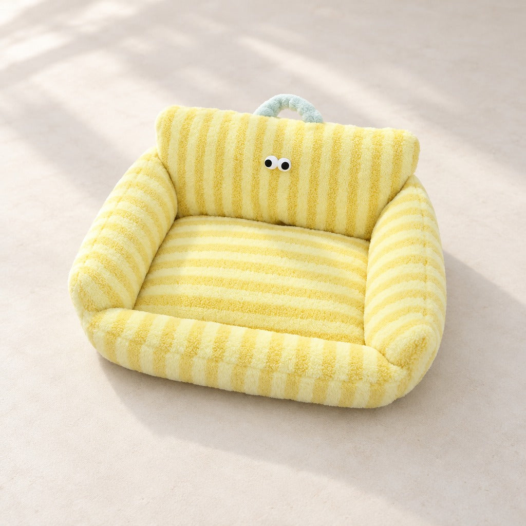 Le couchage canape en peluche rayee jaune vanille seul, vu en plongee, avec sa poignee bleu glacier.