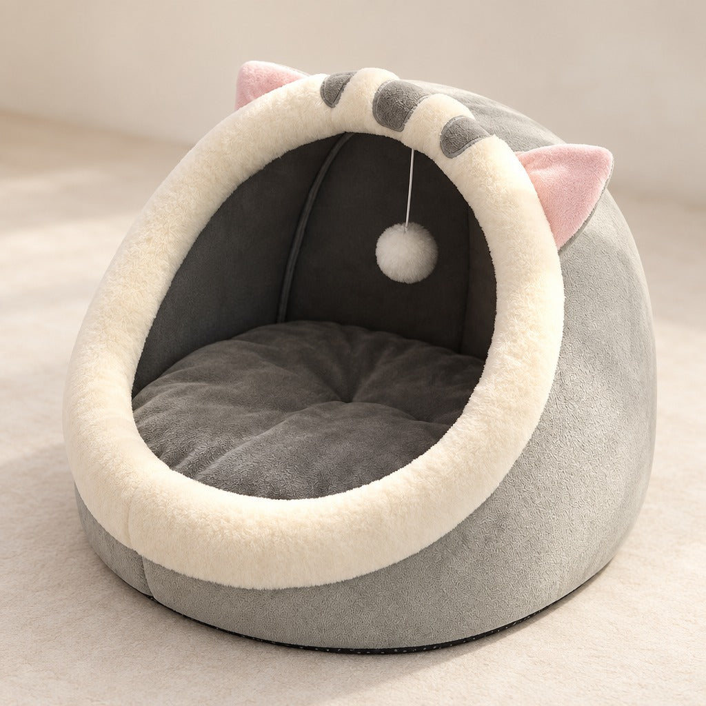 Cocon pour chat gris lin vu de trois quarts, oreilles à revers rose et queue rayée posée sur le dessus.