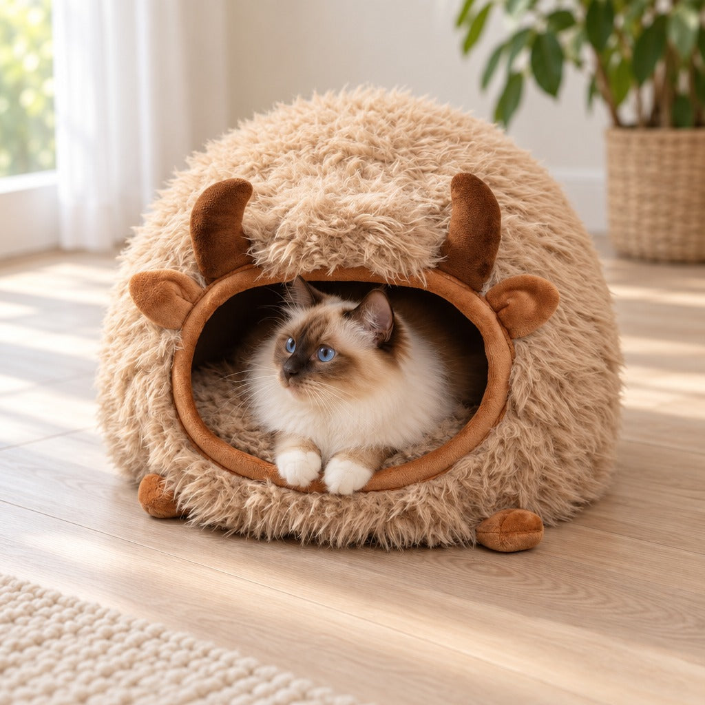 Un chat sacré de Birmanie seal point est couché dans le cocon beige yack, seules sa tête et ses pattes avant sortent de l'ouverture ovale.