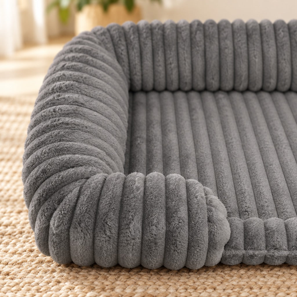 Gros plan sur le bourrelet côtelé et sur un coussinet en forme de patte de la corbeille pour chien, coloris gris ardoise.