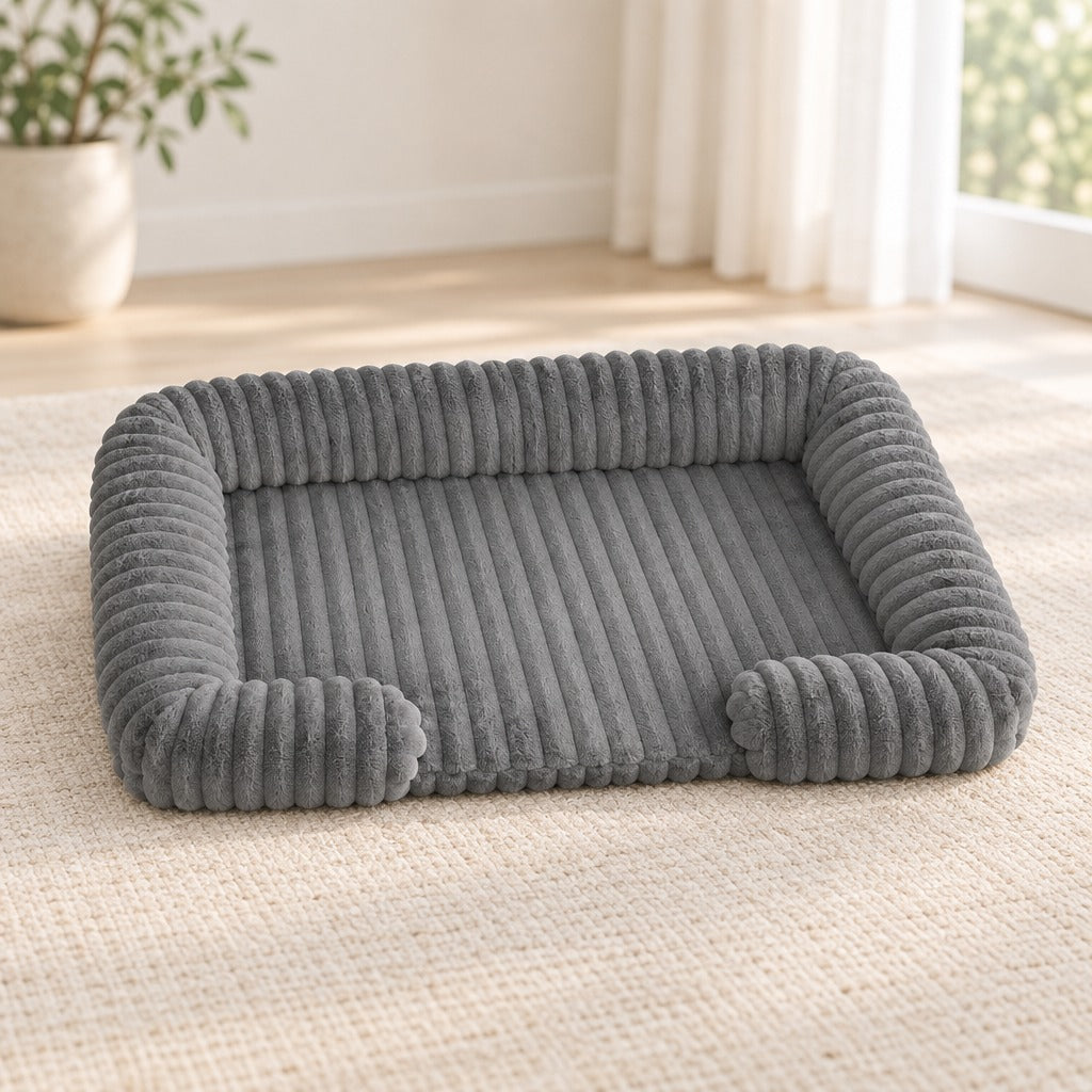 Corbeille pour chien coloris gris ardoise, seule sur un tapis clair, façade basse ouverte vers l'avant.