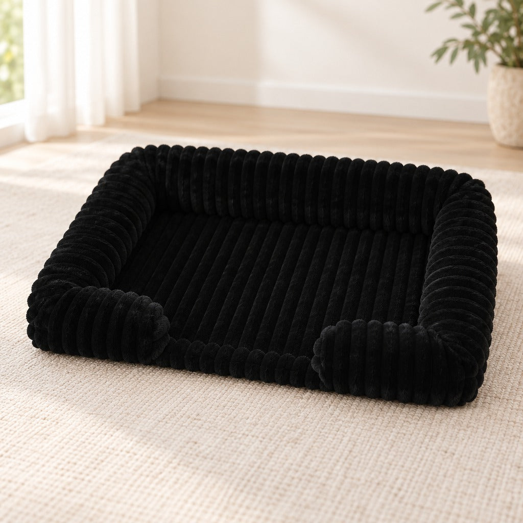 Corbeille pour chien coloris noir, seule sur un tapis écru dans un séjour lumineux.