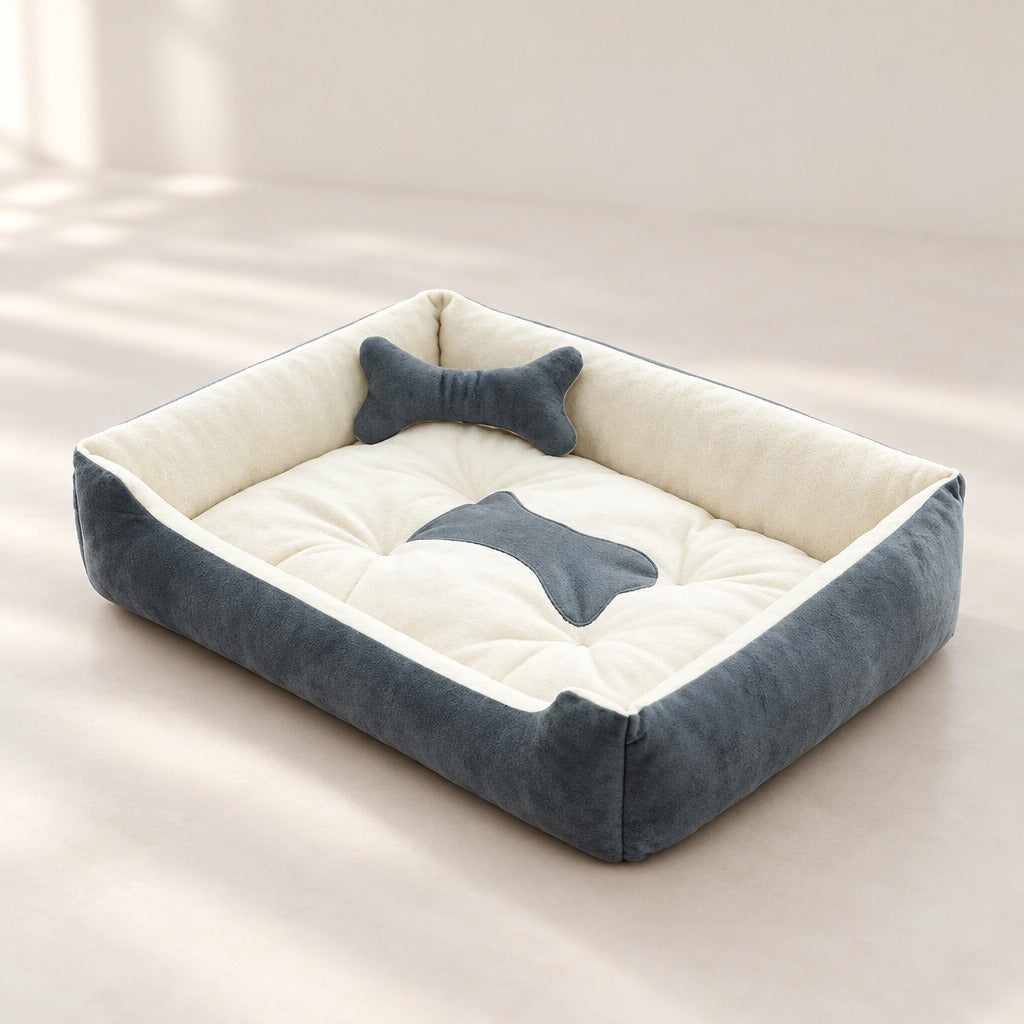 La corbeille gris ardoise et écru seule sur fond clair, ses quatre bords relevés, son matelas matelassé et son coussin en forme d'os.