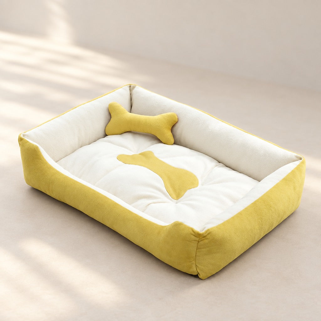 La corbeille jaune moutarde et écru seule sur fond clair, son matelas écru matelassé et son coussin en forme d'os moutarde.