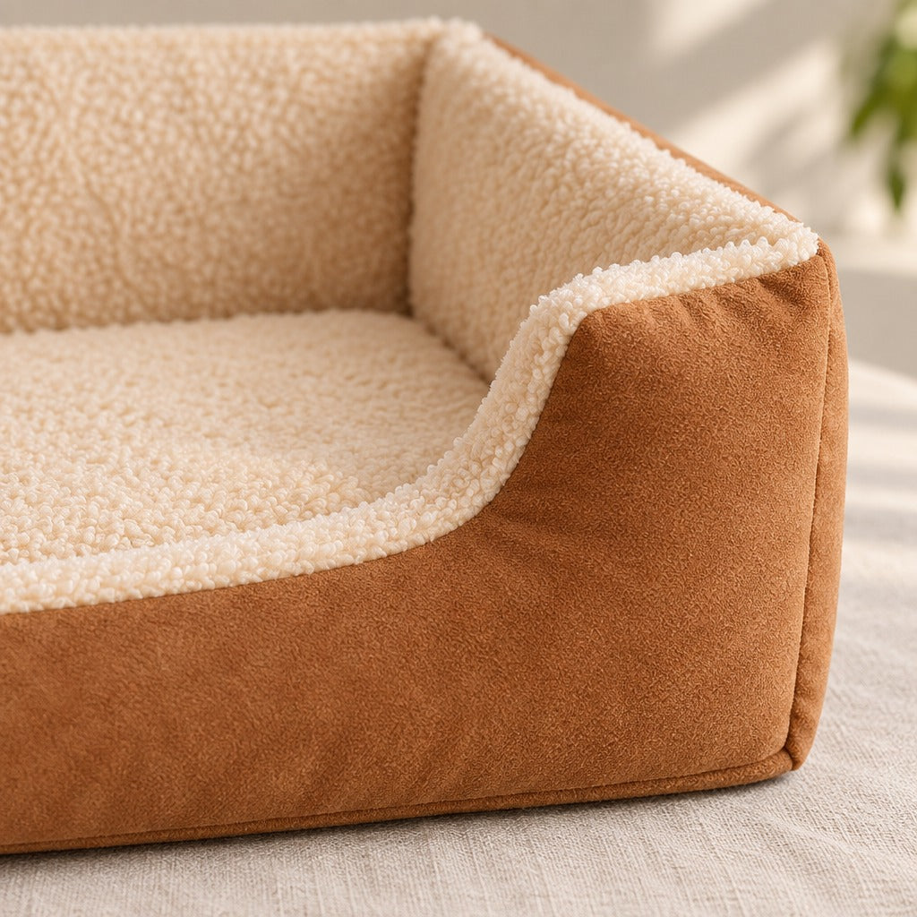 Gros plan sur l'angle avant de la corbeille moelleuse caramel, peluche bouclée crème à l'intérieur et suédine mate à l'extérieur.