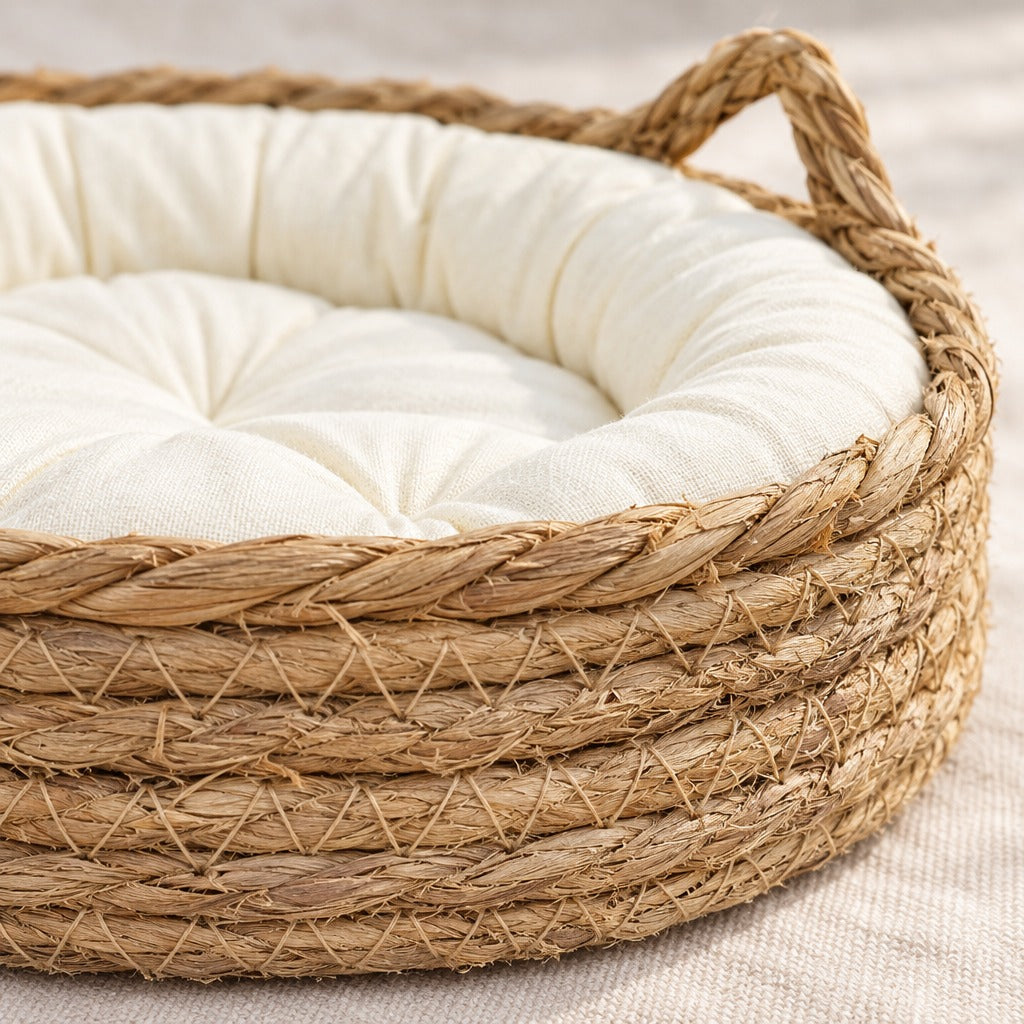 Gros plan sur les rangs de fibre végétale enroulée et cousue de la corbeille pour chat, avec le coussin écru uni au fond.
