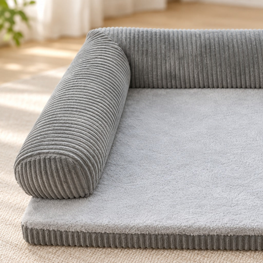 Gros plan sur l'angle droit du boudin en velours côtelé gris et sur la surface de couchage en peluche.