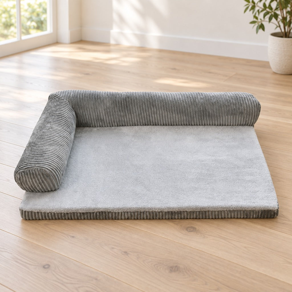 Le coussin en L gris seul sur un parquet clair, ses deux côtés libres au premier plan.