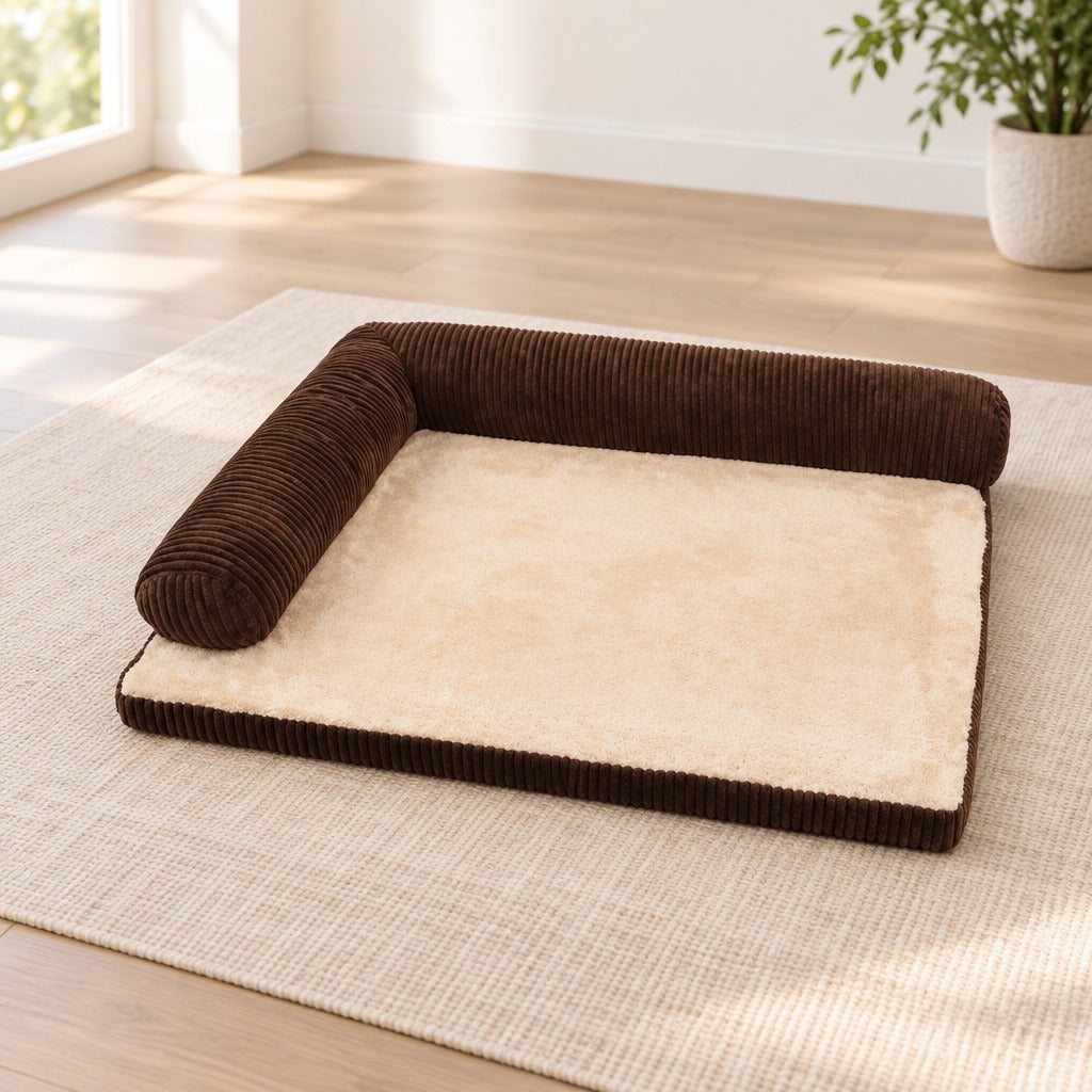 Le coussin en L brun seul sur un tapis de lin clair, vu de trois quarts en hauteur.