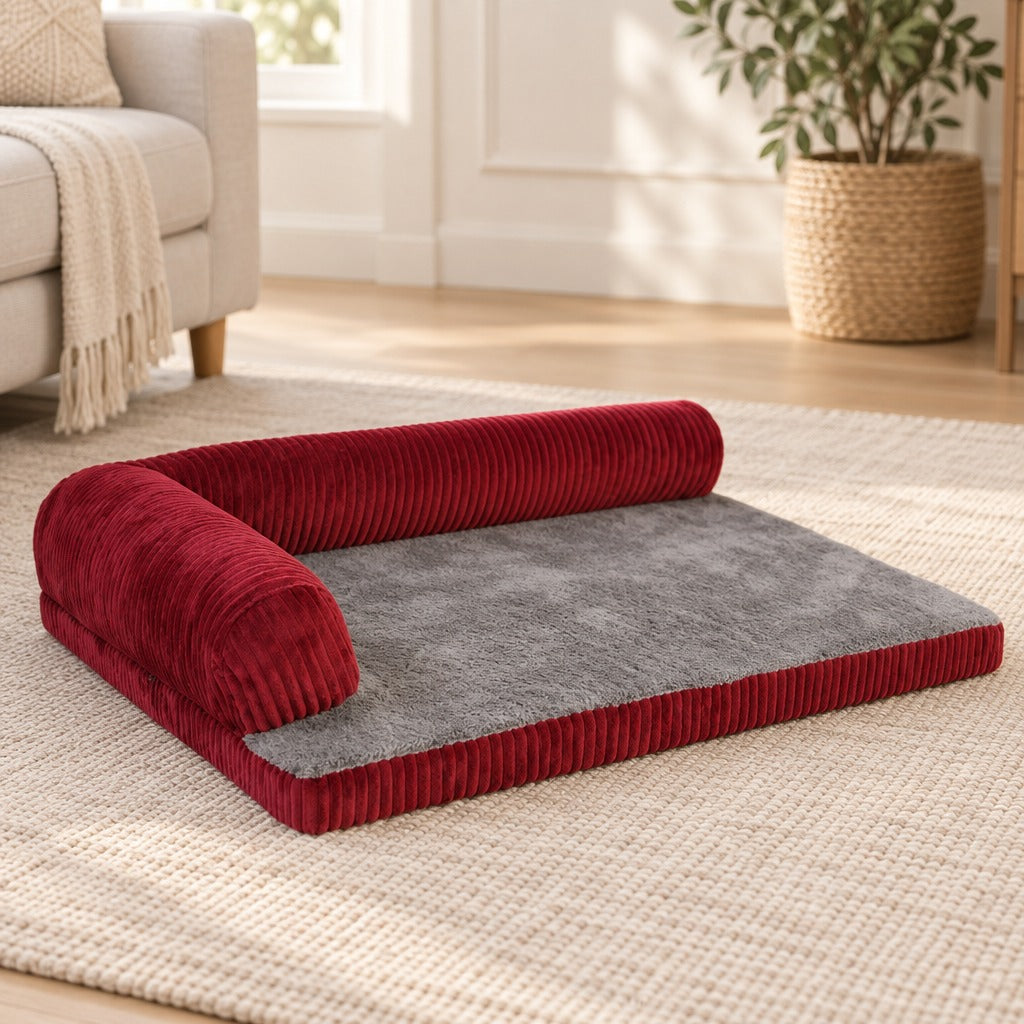 Le coussin en L rouge seul sur un tapis clair, ses deux côtés ouverts face à l'objectif.