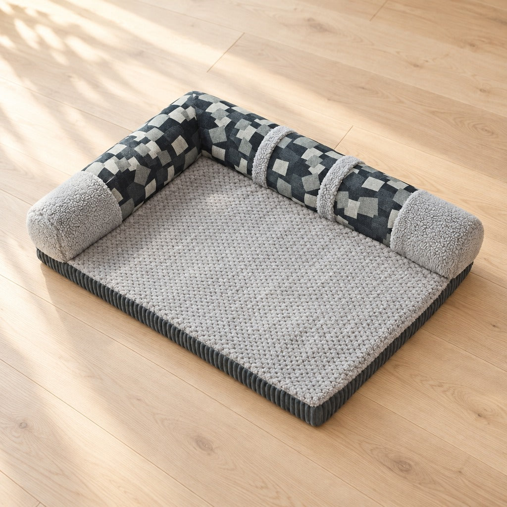 Le coussin en L mosaïque gris bleu seul sur un parquet clair, vu de trois quarts en hauteur.