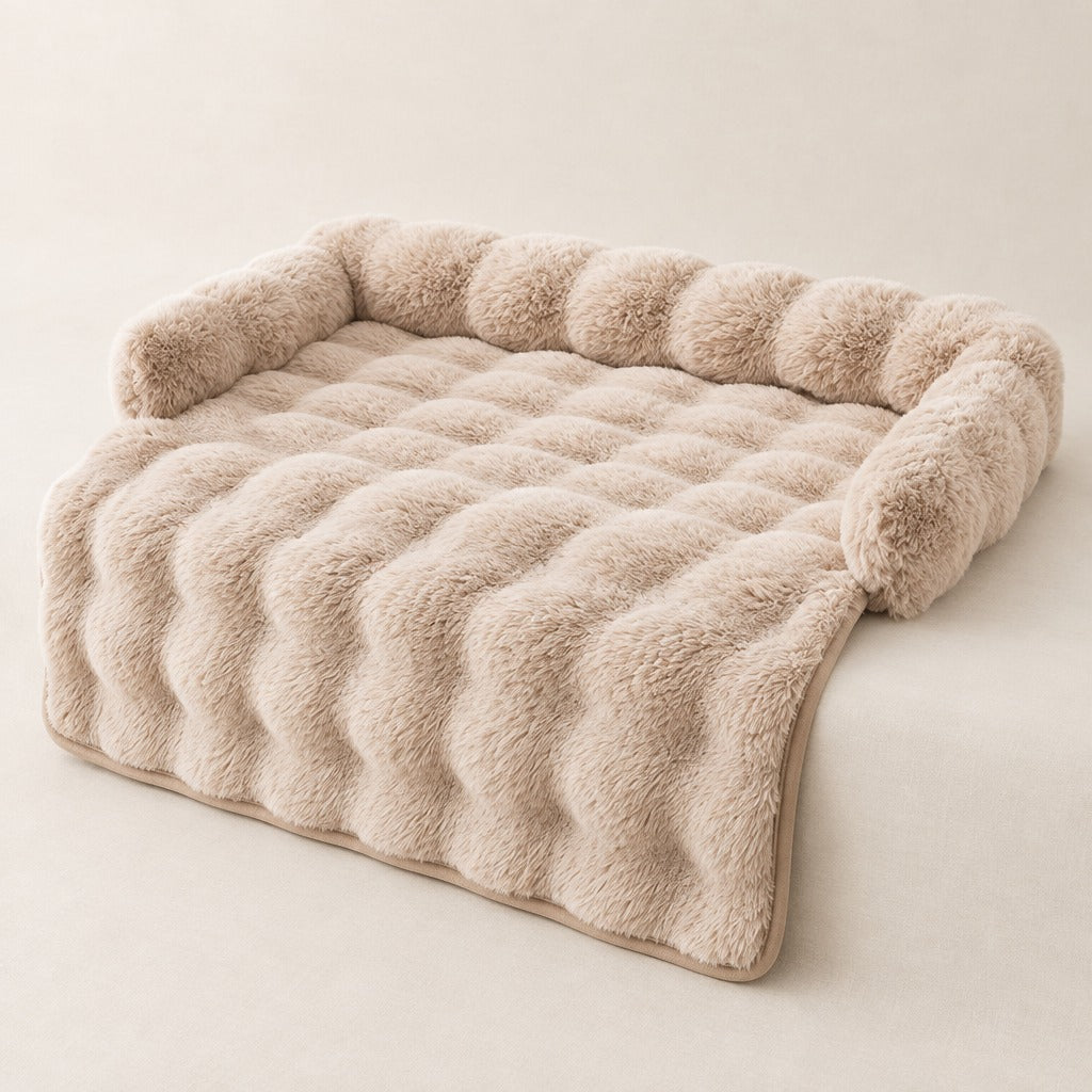 Le couvre canapé beige seul sur un fond de lin clair, avant plat et pan qui retombe.