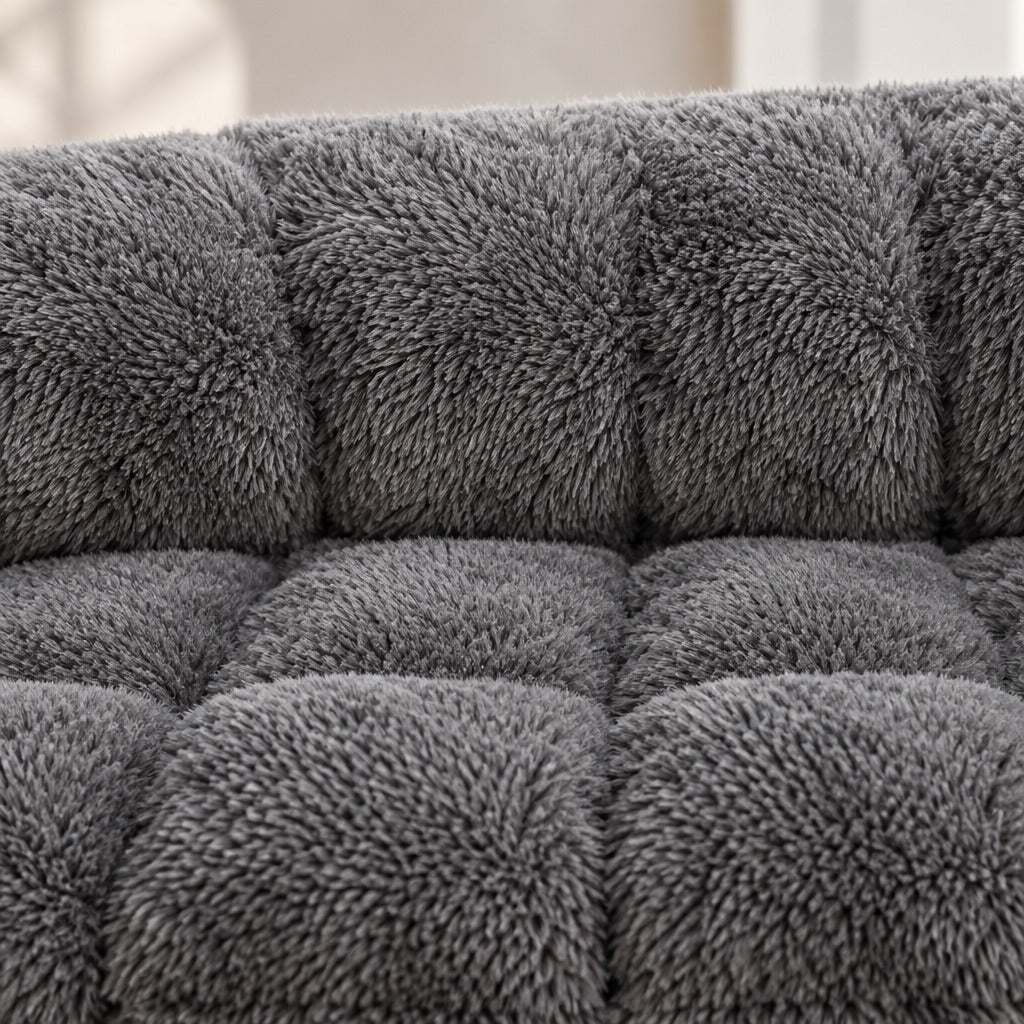 Gros plan sur la peluche matelassée gris anthracite, à la jonction du boudin rembourré et de l'assise plate.