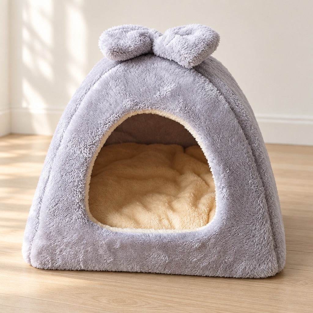 Le dôme en peluche gris perle au poil long vu presque de face, liseré écru autour de l'arche et coussin épais au fond.