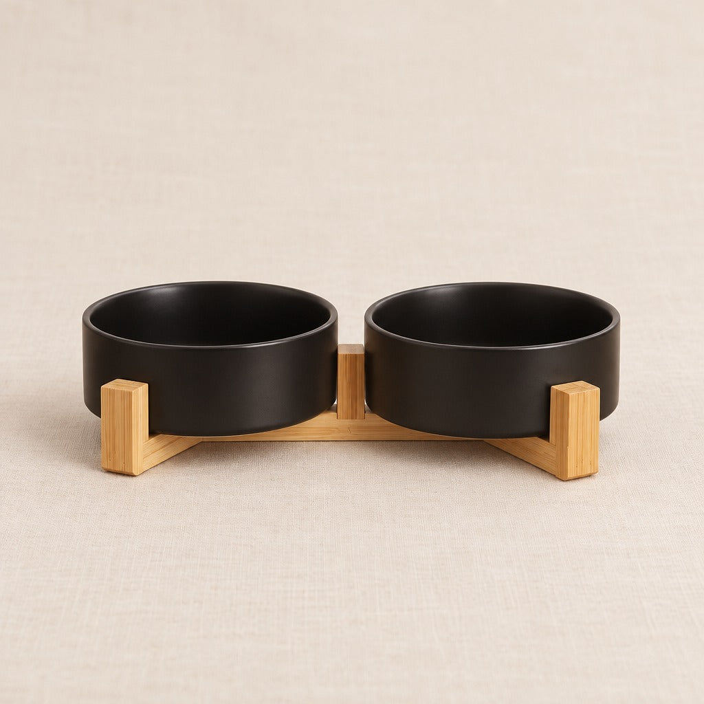 Duo de bols noirs dans son socle de bois clair, seul sur un fond clair, vu de trois quarts.