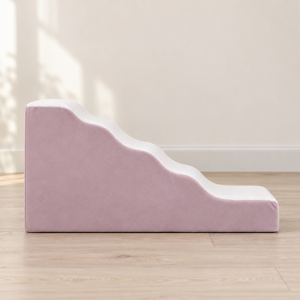 L'escalier rose poudré grand modèle vu seul de profil sur un parquet clair devant un mur crème.
