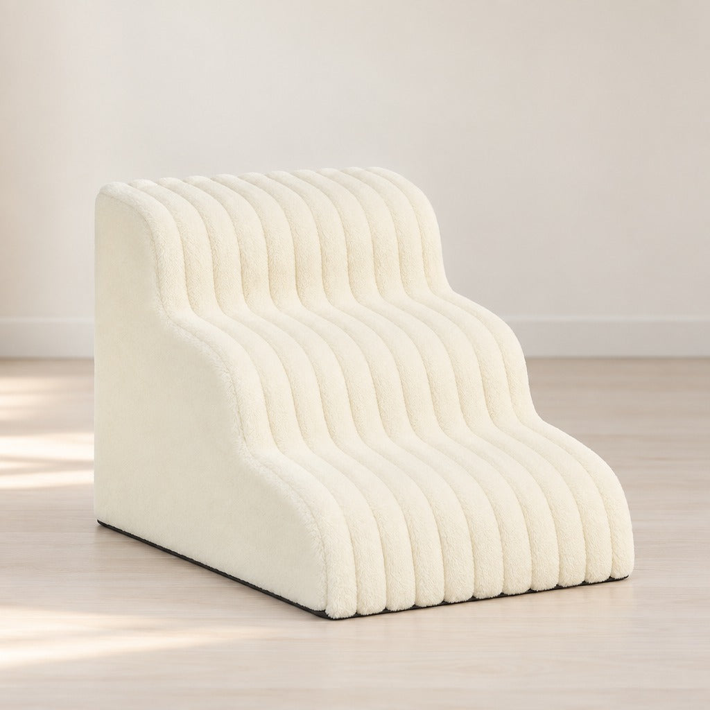 L'escalier blanc crème seul sur fond clair, ses trois marches côtelées et son flanc parfaitement lisse.