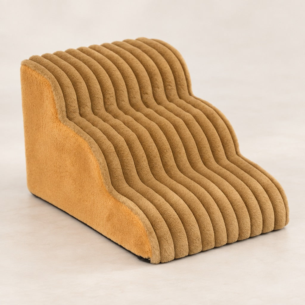 L'escalier caramel seul sur fond clair, vu de trois quarts, ses trois marches côtelées et son flanc lisse.