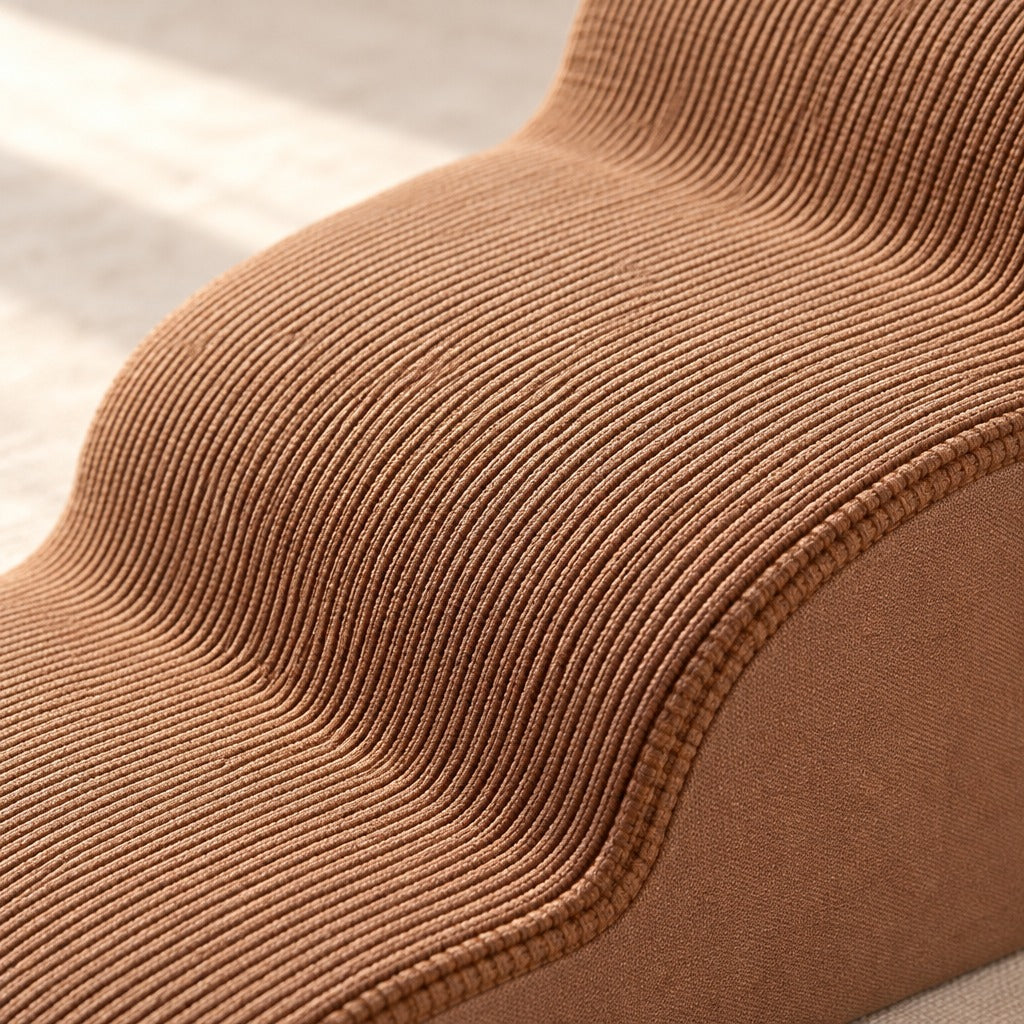 Gros plan sur le tricot à côtes brun cannelle des marches et sur le passepoil de couture qui suit la vague.