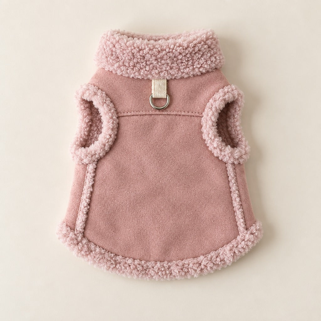 Gilet coloris rose poudré seul, posé à plat de dos sur un fond neutre clair, col en bouclette en haut et ourlet bordé en bas, sans animal.