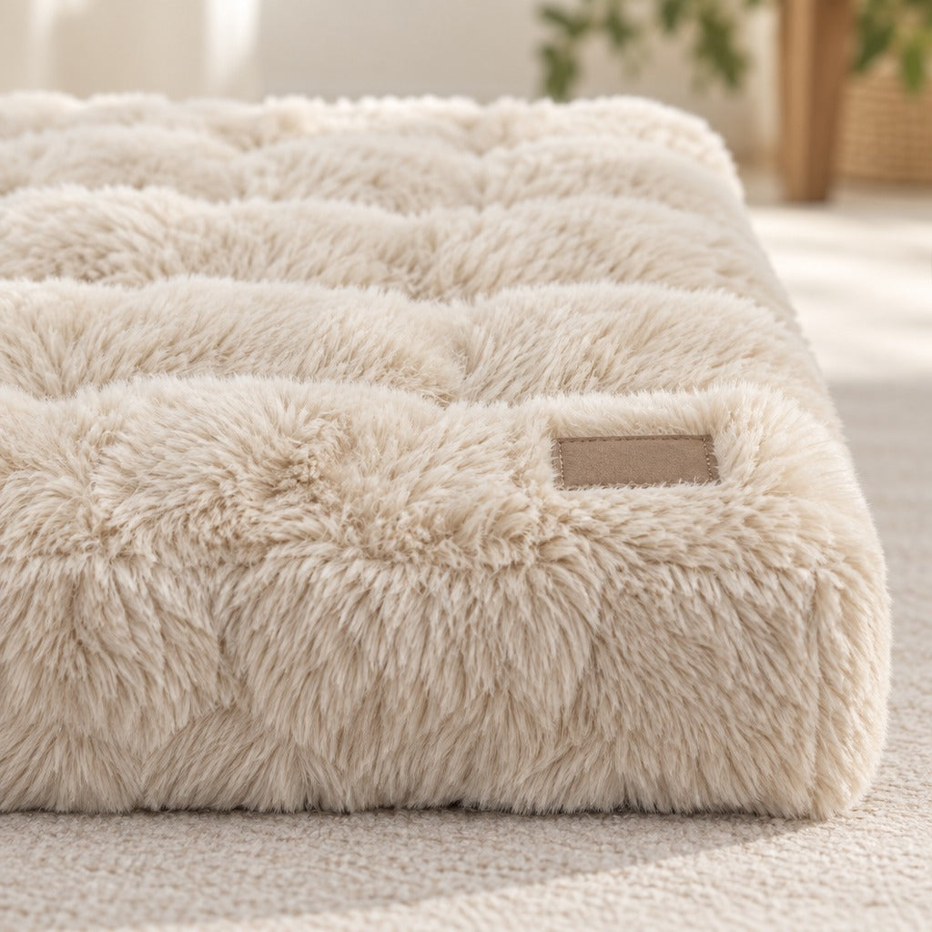 Gros plan sur un angle du matelas crème, ses bossages matelassés et sa fourrure à poil long.