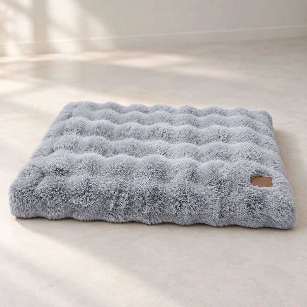 Le matelas gris bleuté seul, posé à plat sur un sol clair et neutre.