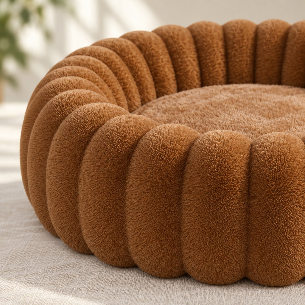 Gros plan sur la peluche à poil ras des nervures caramel et sur le plateau d'assise plus clair du couchage rond.