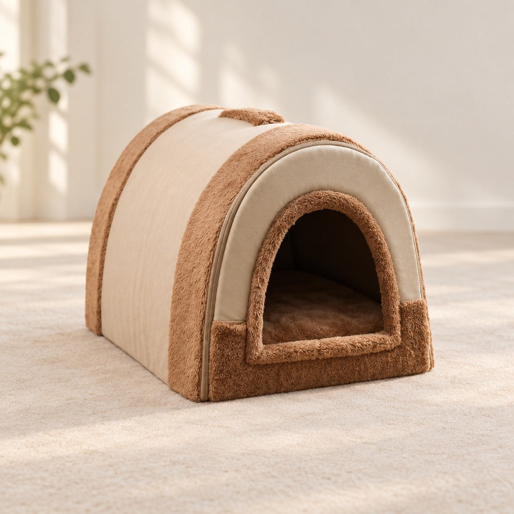 Niche pour chien brun clair camel posée seule sur un sol clair, vue de trois quarts, ouverture tournée vers la droite.