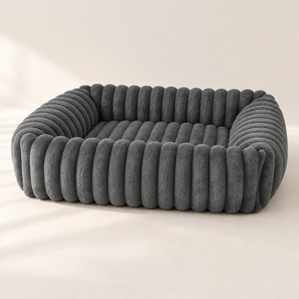 Panier cannelé gris ardoise pour chien vu de trois quarts, rebord matelassé continu et surface de couchage en creux.