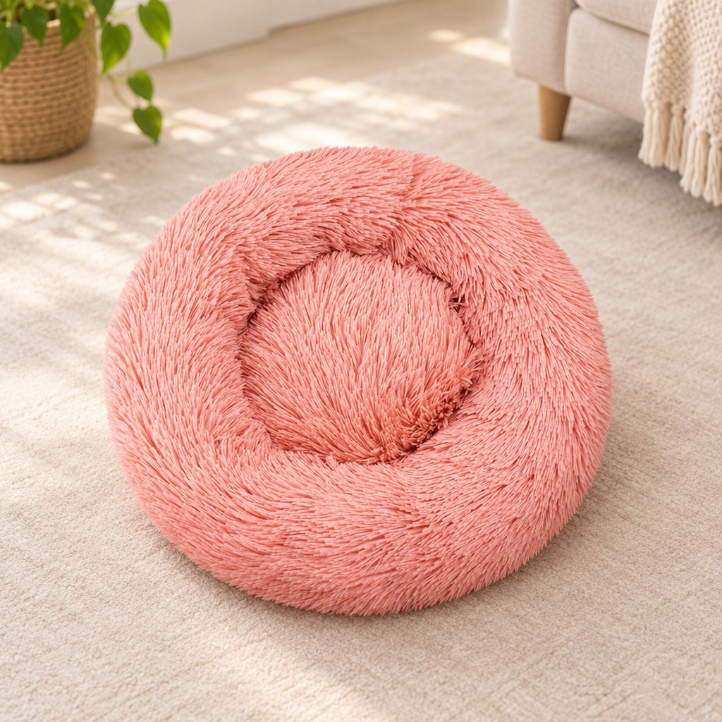 Le panier rond rose corail seul sur un sol clair, vu de trois quarts, son bourrelet continu et son creux central plat.