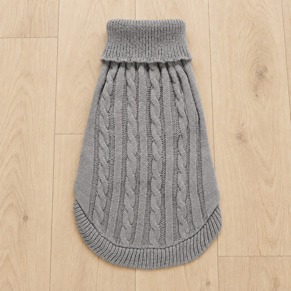 Le pull pour chien seul, à plat sur un parquet clair, coloris Gris flanelle, du col roulé à l'ourlet côtelé.