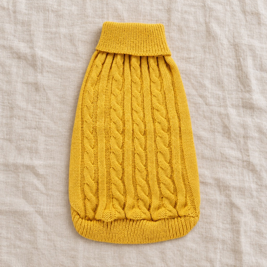Le pull pour chien seul, à plat sur un drap de lin, coloris Jaune moutarde, du col roulé à l'ourlet côtelé.