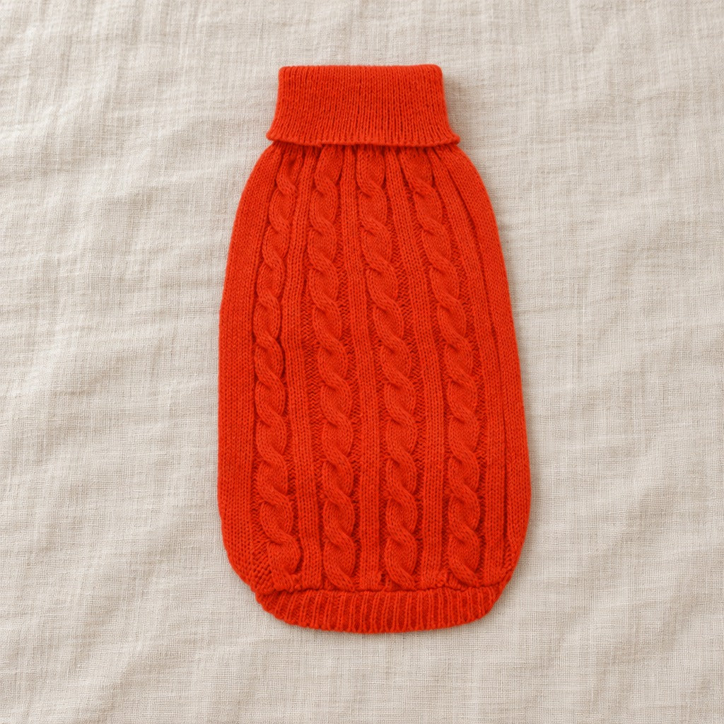 Le pull pour chien seul, à plat sur un drap de lin, coloris Rouge coquelicot, du col roulé à l'ourlet côtelé.