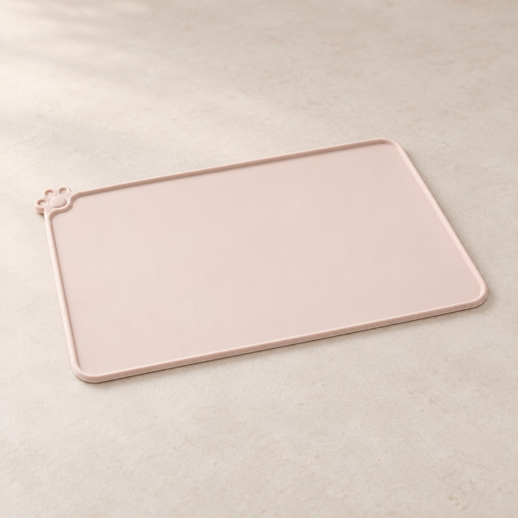 Le set de table beige rosé seul sur une surface claire et unie, vu de trois quarts.