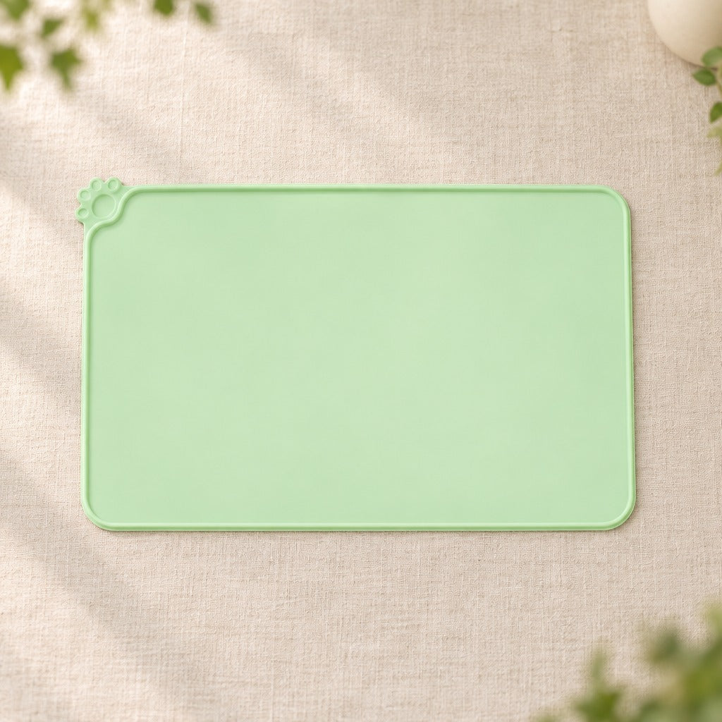 Le set de table vert amande seul sur une toile de lin claire, vu presque de dessus.