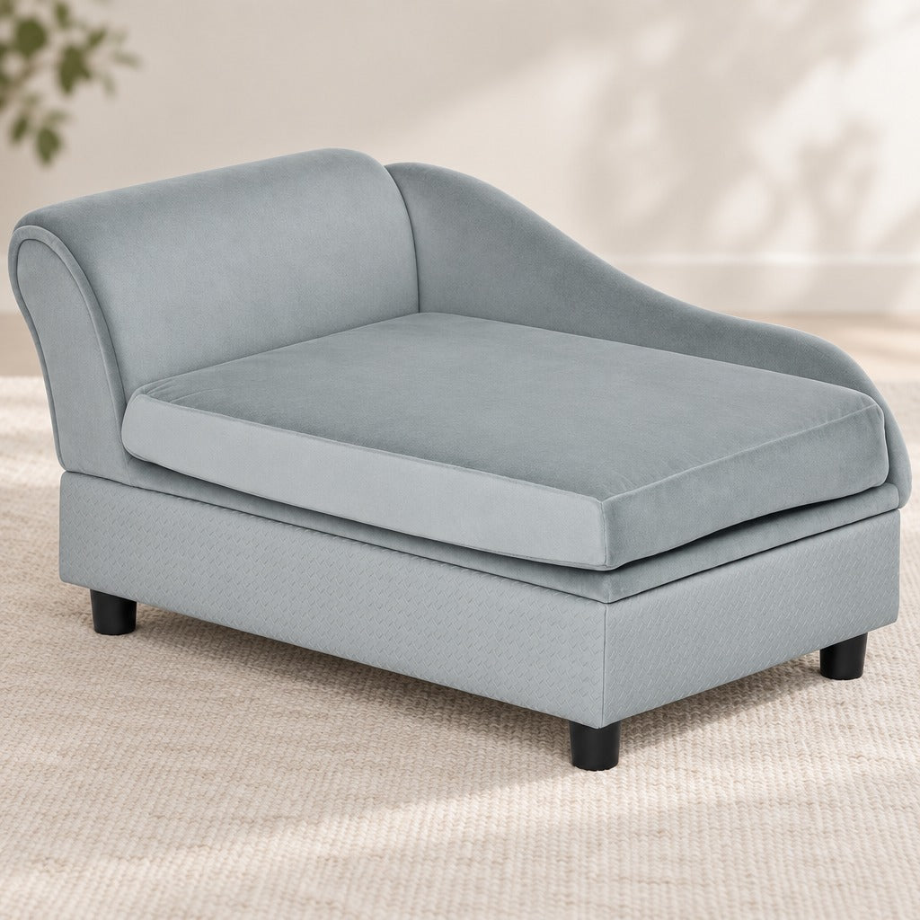 Le sofa gris clair seul, vu de trois quarts, son unique accoudoir enroulé à gauche, son dossier descendant et ses quatre pieds noirs.