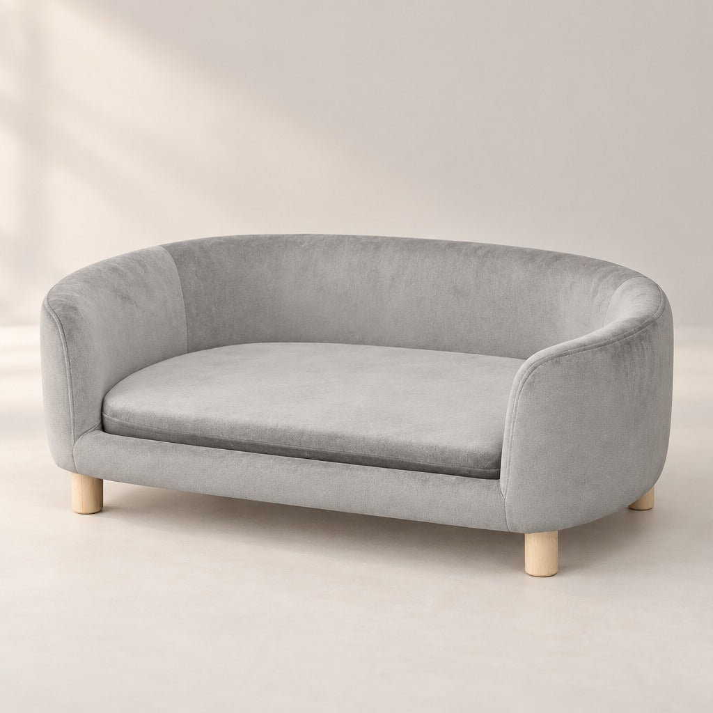 Sofa compact gris perle seul, vu de trois quarts avant, coussin en place et quatre pieds en bois clair.