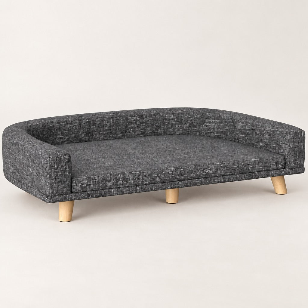 Le sofa gris foncé pour chien, vu de trois quarts et seul sur un fond neutre clair.