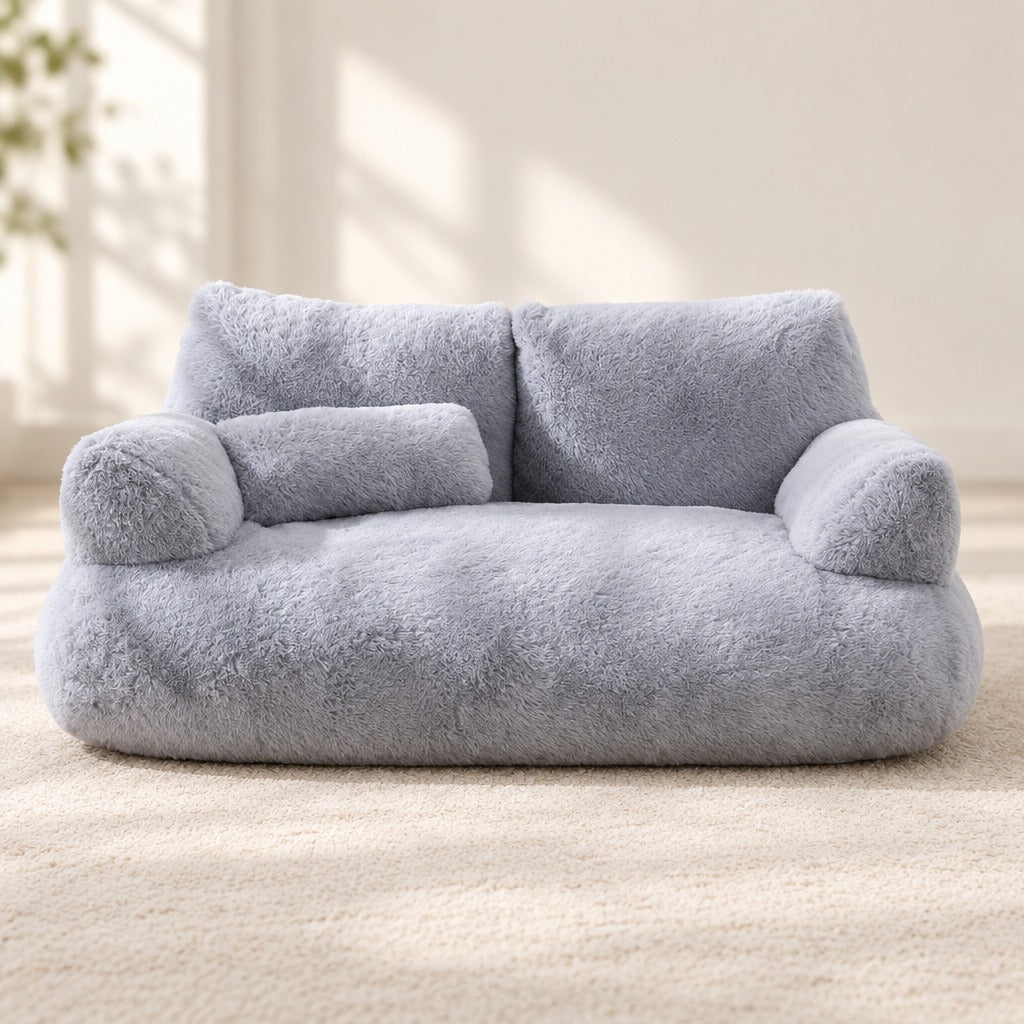 Le sofa moelleux gris nuage vu de face en entier, son dossier bas à deux coussins et son traversin posé sur l'assise