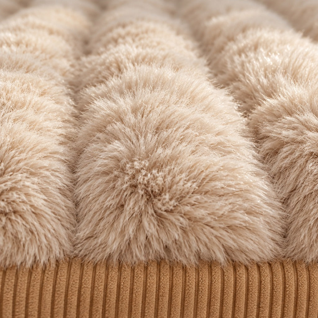 Gros plan sur la fourrure synthétique crème du couchage et sur le velours côtelé camel du socle du sofa en peluche pour chien.