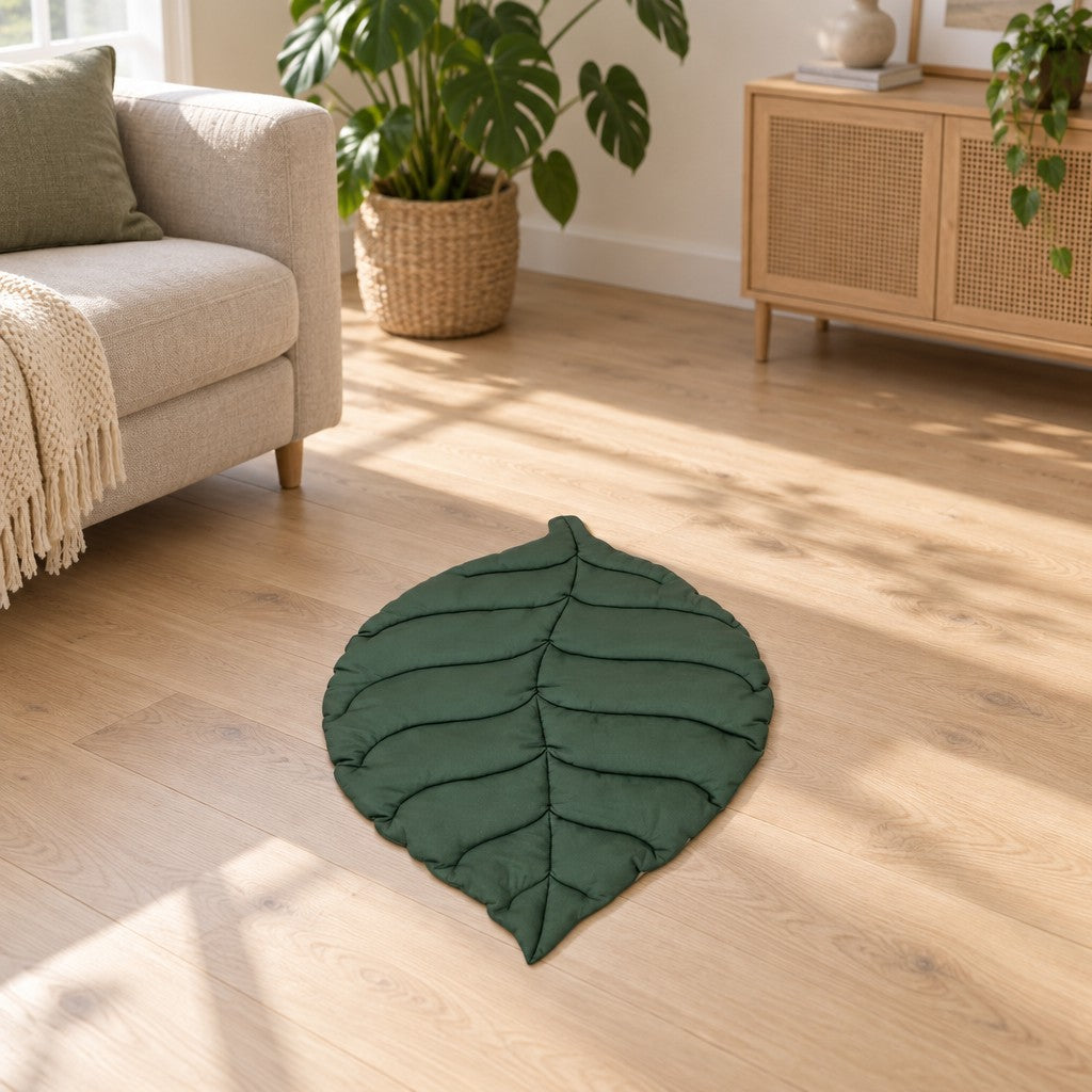 Le tapis feuille vert déroulé au sol dans un salon clair, entre un canapé en lin et une plante