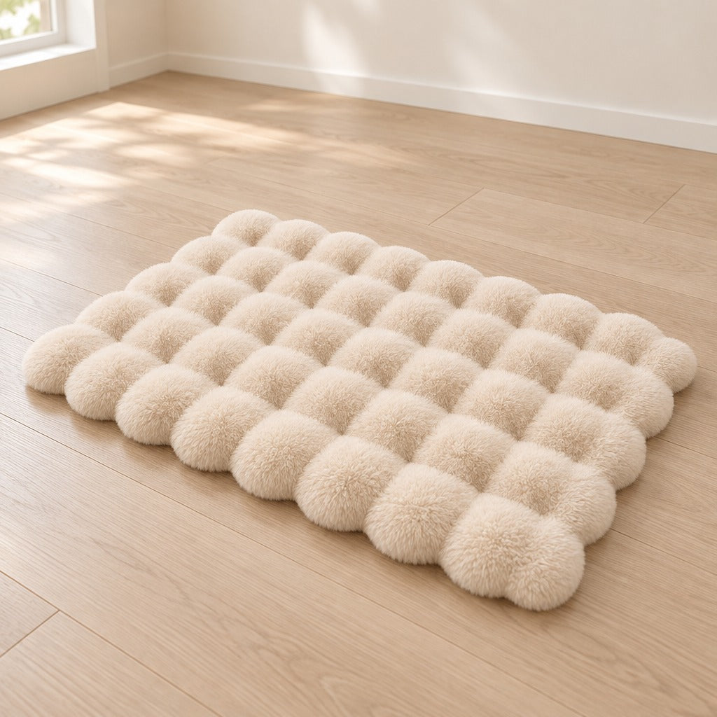 Le tapis crème seul, posé à plat sur un parquet clair, sa grille de bulles et son contour festonné visibles.