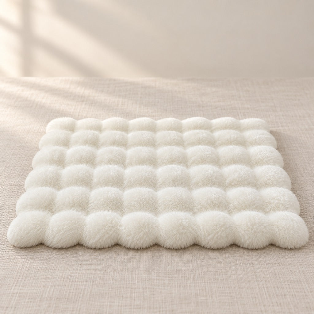 Le tapis blanc seul, posé à plat sur une toile de lin claire, vu de face.