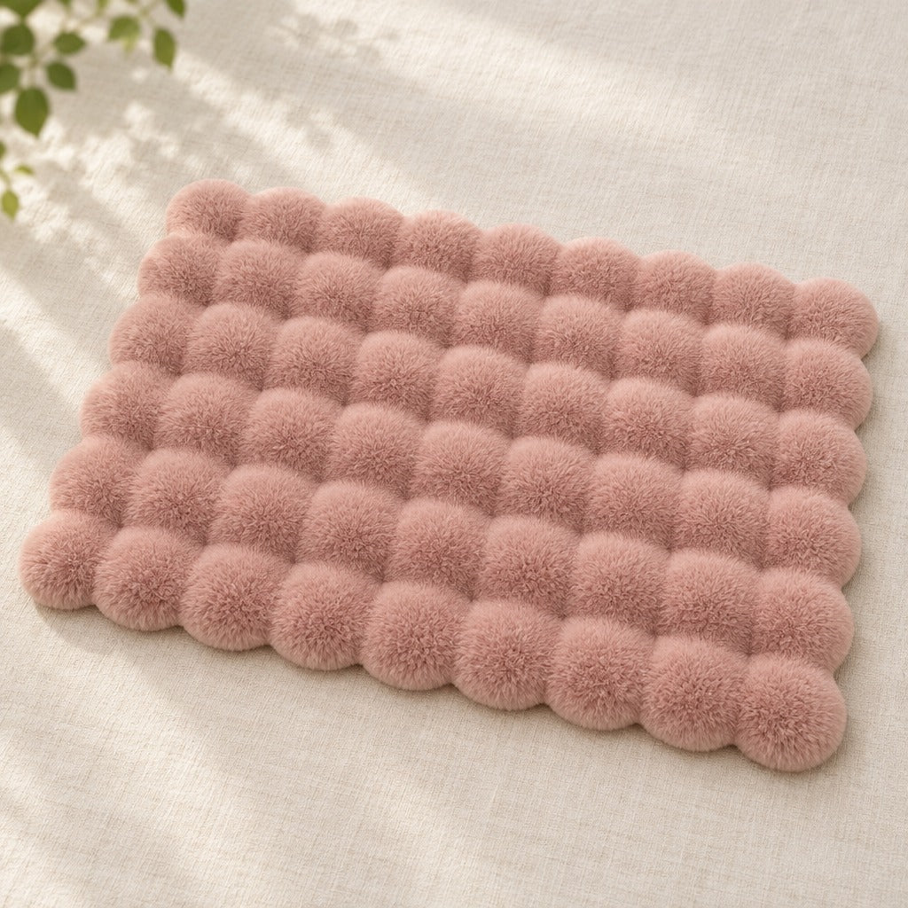 Le tapis rose poudré seul, vu de dessus sur une toile claire, toute sa grille de bulles lisible.